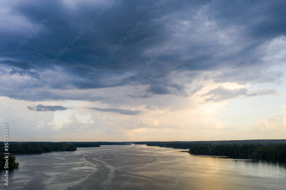 Fototapeta premium panoramic view of the river with floating boats and beautiful clouds shot from a drone