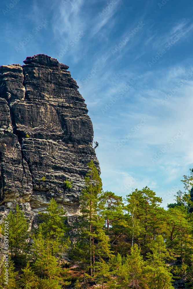 Sandstone rock formation the locomotive in German-Saxon Switzerland with climbers on the right, vertical photo