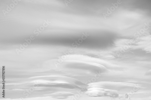 Different shapped clouds in a blue sky in black and white