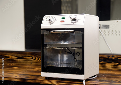 dry-air sterilizer standing on a table for processing tools in a beauty salon