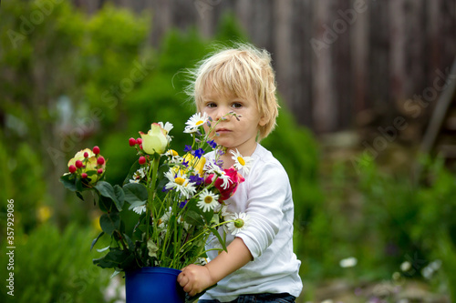 Child holding rubber boots with beautiful flowers