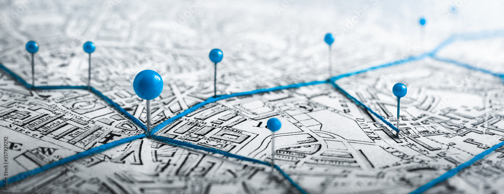 Obraz premium Trasy z niebieskimi pinezkami na mapie miasta. Koncepcja dotycząca przygody, odkrywania, nawigacji, komunikacji, logistyki, geografii, transportu i podróży.