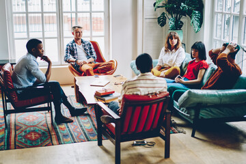 Serious adult multiethnic business people discussing work in cozy modern office