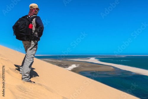 Tourist admiring the view from a sand dune at Sandwich Harbour