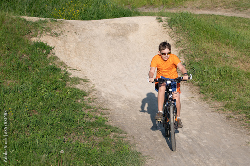 Fototapeta Naklejka Na Ścianę i Meble -  child riding a bike on a dirt road