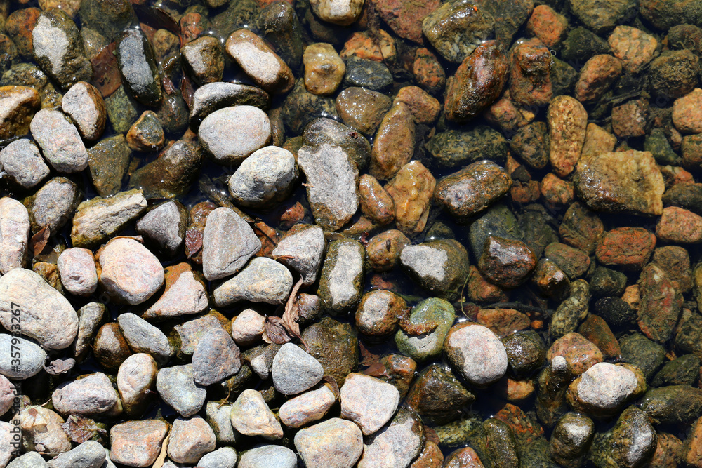 Wet pebble stones in a closeup. Colorful texture image. Wet pebble stones in a closeup. Colorful texture image.