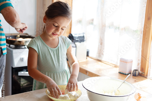 Loving caring grandmother, beautiful senior woman, baking tasty sweet cookies together with her granddaughter, cute little toddler girl