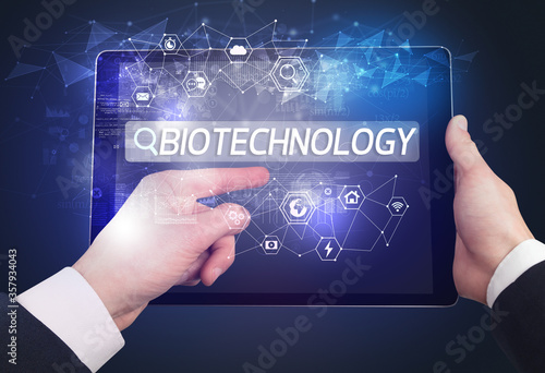 Close-up of a tablet searching BIOTECHNOLOGY inscription, hi-tech computing concept