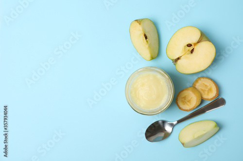 Fototapeta Naklejka Na Ścianę i Meble -  Glass jar with apple puree on blue background, top view