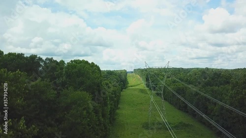 Aerial view of a line of high voltage transmission going through the forest. photo