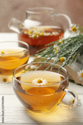 Composition with chamomile tea on white wooden background