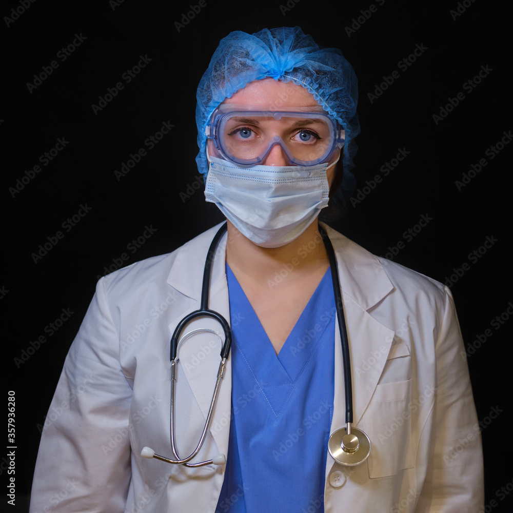 A doctor in protective medical clothing with a stethoscope, black background. A nurse in a white coat and blue uniform with a cap, close-up A doctor in protective medical clothing with a stethoscope, black background. A nurse in a white coat and blue uniform with a cap, close-up
