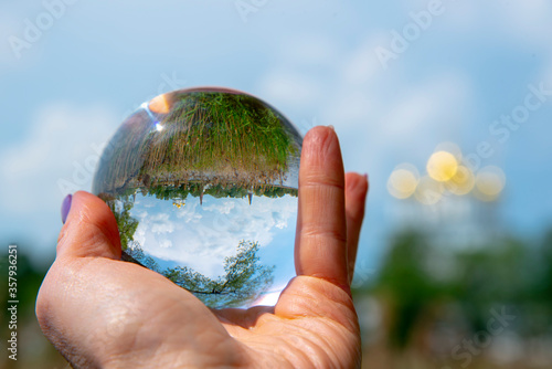 The glass ball lies in the woman's palm.