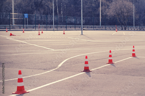 Orange cones on the site at a driving school and driving training with the road for students