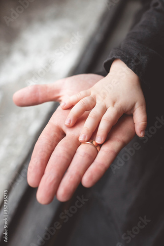 Adult hand holding kid hand  Family Help Care Concept  small hand in fathers hand.
