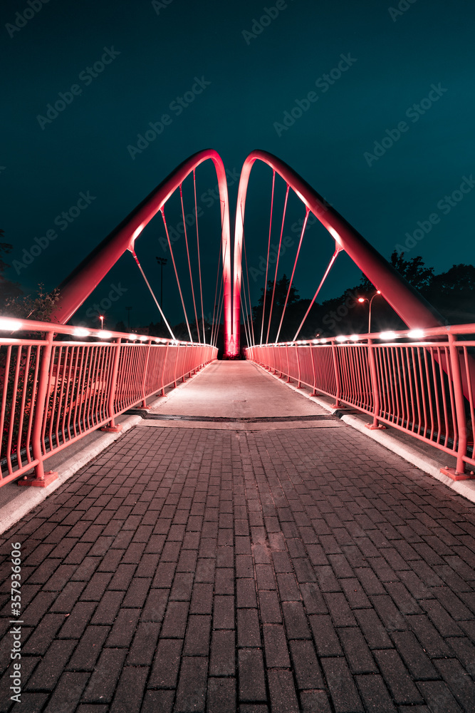 Bydgoszcz by night. The famous bicycle footbridge over the University route in night city lights.
