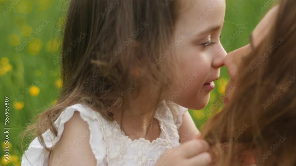 mother and daughter walk in a yellow field in the summer in a straw hat mother and daughter walk in a yellow field in the summer in a straw hat