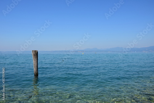 Holzpfahl im Wasser als Anlegestelle für Boote und Schiffe am Gardasee in den Sommermonaten  © Zeitgugga6897