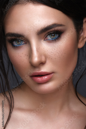 Beautiful girl with bright fashionable make-up  freckles and blue eyes. Beauty face.