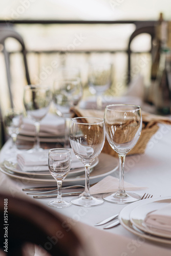 wine glasses on the festive table with white tablecloth © Tetiana