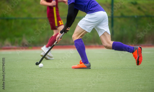 Two field hockey player, fighting for the ball on the midfield during an intense match on artificial grass