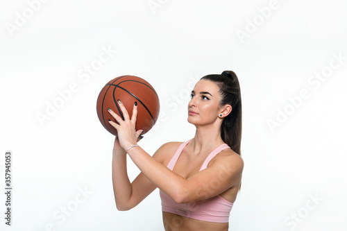 Portrait of a beautiful and girl with a basketball in studio. Sport concept isolated on white background.