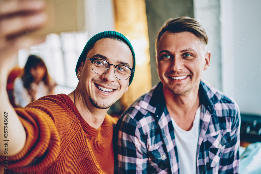 Obraz premium Cheerful friends taking self modern portrait together