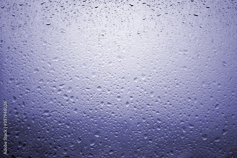 Obraz premium Drops of rain on a window glass with very diffuse landscape navy blue color