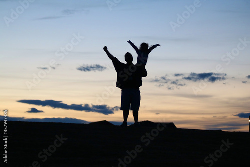 Daddy daughter moment, cheering on a sunset