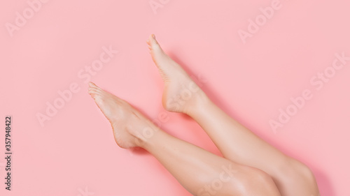 Female shaved legs against pink colored background. Removal hair. Minimalism. Top view. Body hygiene  spa procedures banner. Smooth skin