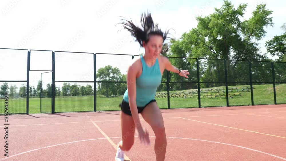 Fitness woman in sportswear doing various exercises on an orange basketball field with white markings, at the stadium. Outdoor sports. online training. summer day. Fitness woman in sportswear doing various exercises on an orange basketball field with white markings, at the stadium. Outdoor sports. online training. summer day.