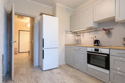 The interior of a small cozy kitchen in the apartment, the interior door to the kitchen is open