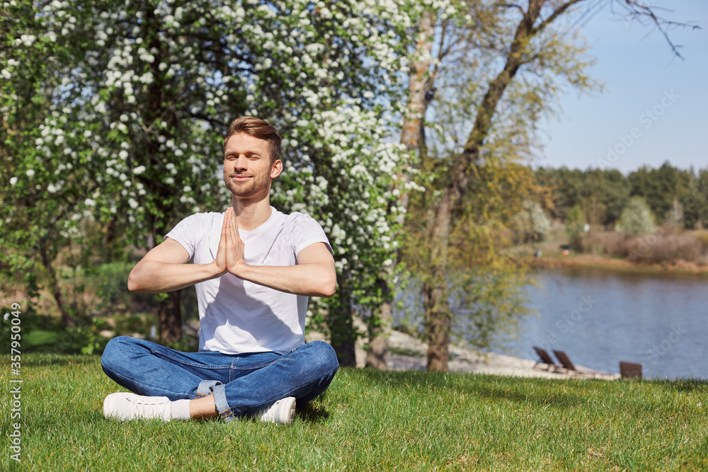 Obraz premium Restful bearded man training yoga exercises in open air