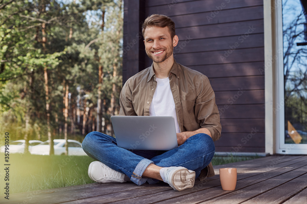 Obraz premium Handsome young man with a laptop outdoors