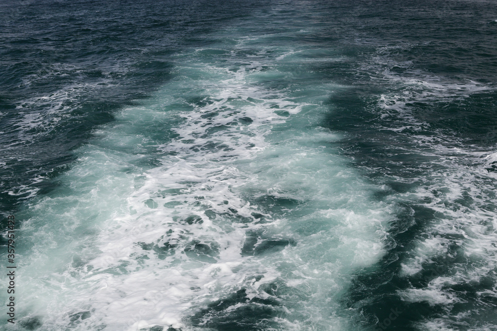 Trail on water surface behind of fast moving ship Trail on water surface behind of fast moving ship
