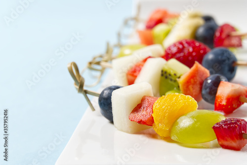 Fruit canapes. Fresh fruit canapes on white plate. Mixed fruit in white plate healthy food style, blue backgrounds.