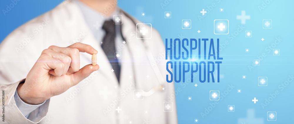 Close-up of a doctor giving a pill with HOSPITAL SUPPORT inscription, medical concept Close-up of a doctor giving a pill with HOSPITAL SUPPORT inscription, medical concept