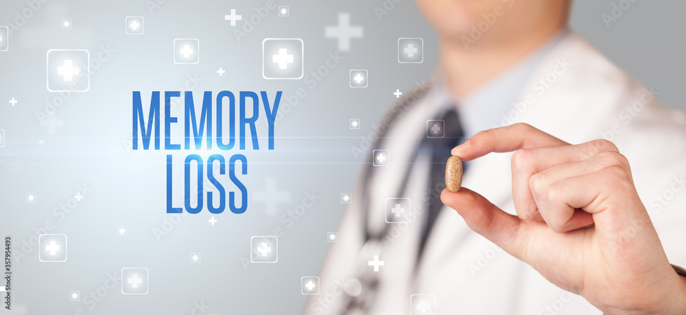 Close-up of a doctor giving a pill with MEMORY LOSS inscription, medical concept