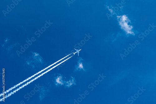 Fototapeta Naklejka Na Ścianę i Meble -  Airplane streaking across the blue sky