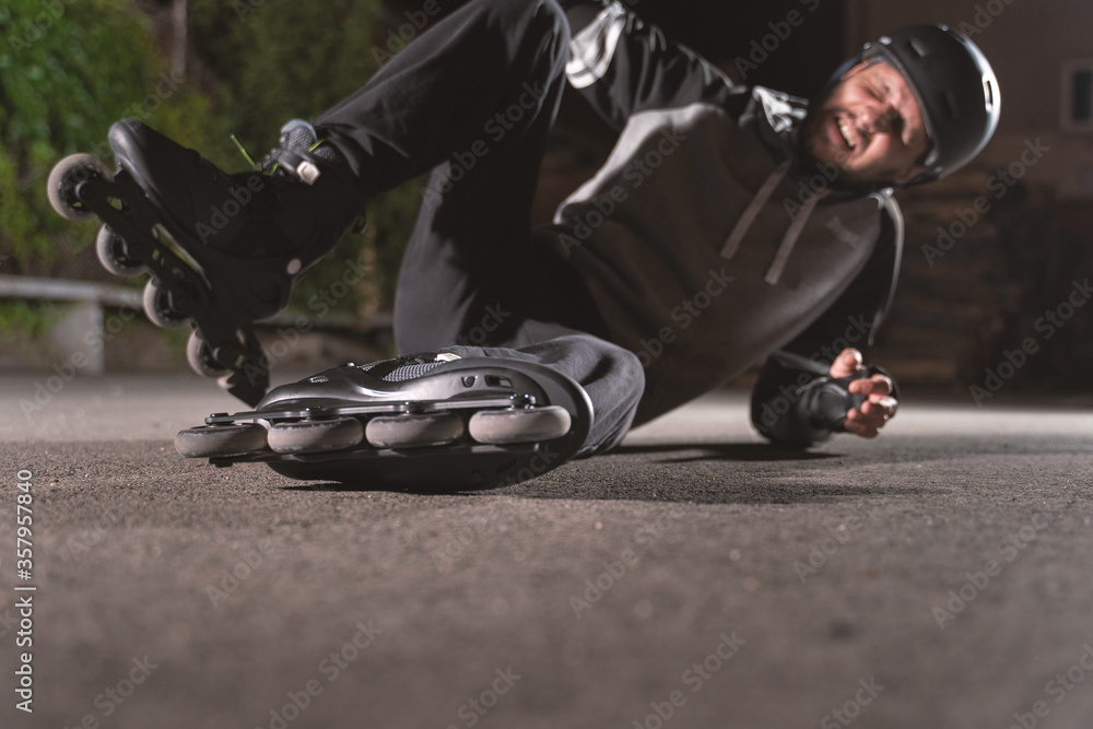 Selective focus inline roller skates caucasian man fallen on the