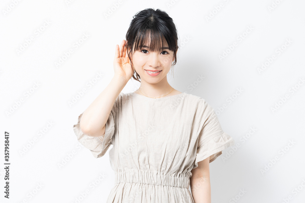 聞き耳をたてる若い女性 聞き耳をたてる若い女性