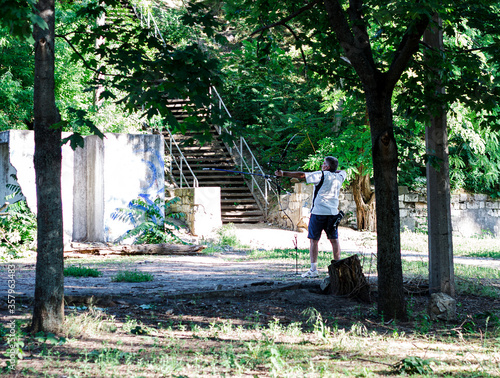 Nikolaev, Ukraine- June 6, 2020: male archer practices shooting from a crossbow in the park in a bright sunny day