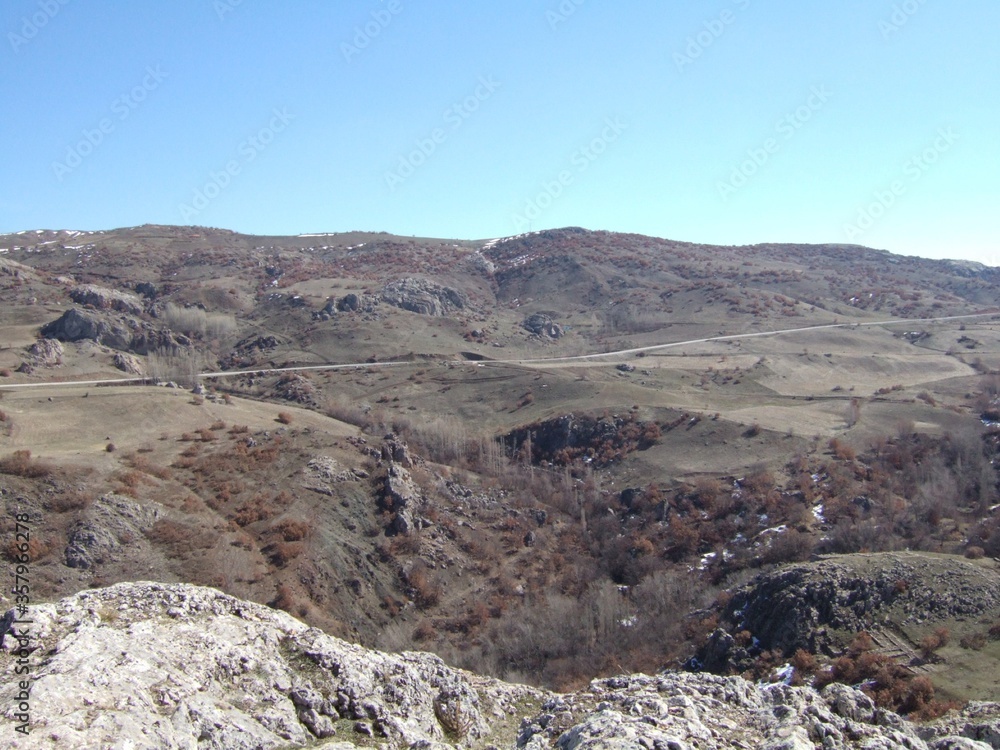 Obraz premium Former fortress on a hilltop stretching toward mountain in rural area