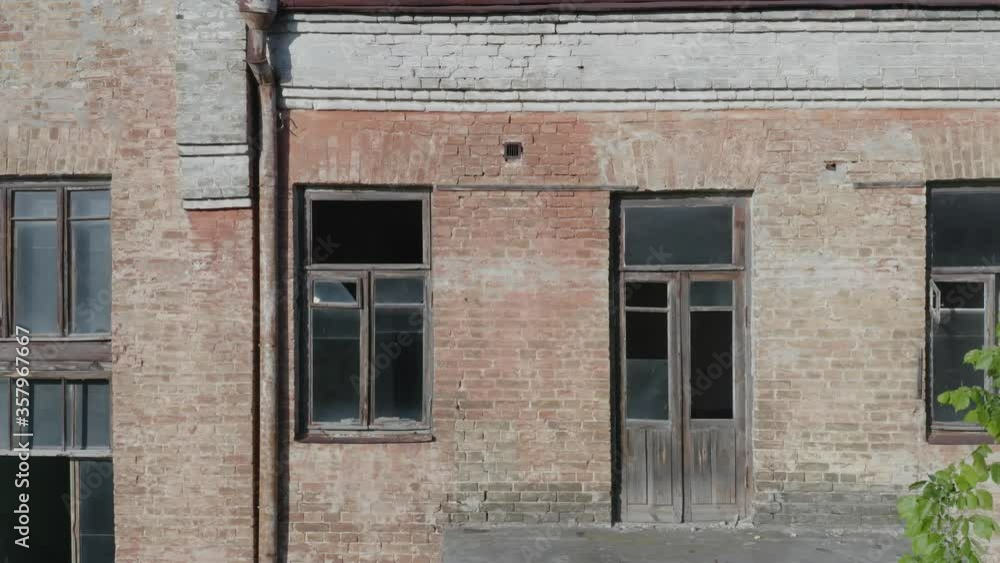Broken windows and balconies of an abandoned early 20th century apartment house (multi-story building). Aerial side view Broken windows and balconies of an abandoned early 20th century apartment house (multi-story building). Aerial side view