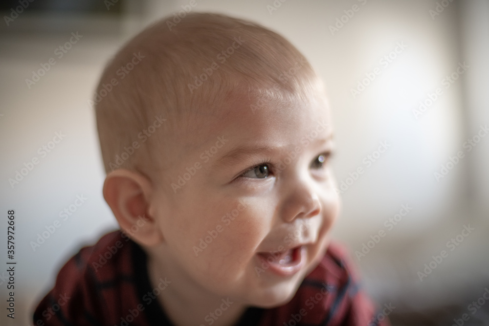 Bebé rubio en cama matrimonial sonriendo mirando hacia su izquierda Bebé rubio en cama matrimonial sonriendo mirando hacia su izquierda