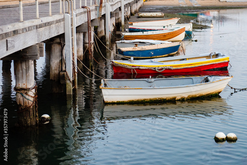 Row of old small boats moored to jetty, Victoria, Australia