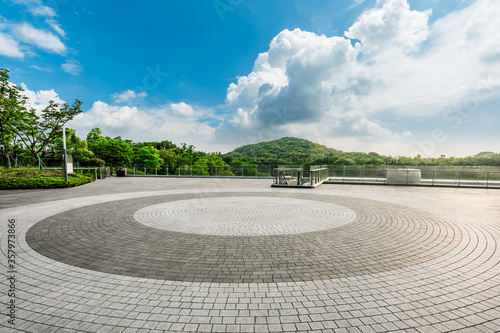 Empty square floor and green mountain landscape.