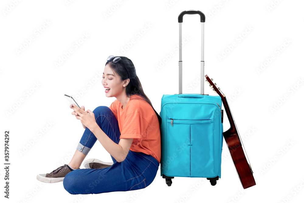 Asian woman sitting with a suitcase holding mobile phone Asian woman sitting with a suitcase holding mobile phone