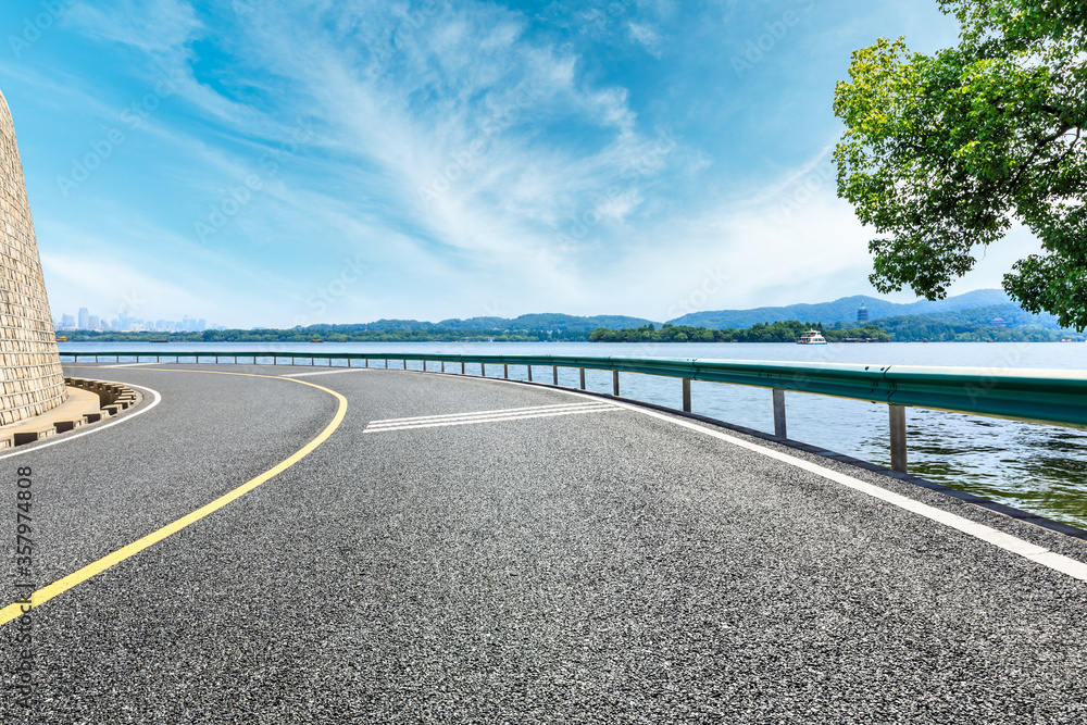 Asphalt road and lake with green mountain landscape in hangzhou,China.
