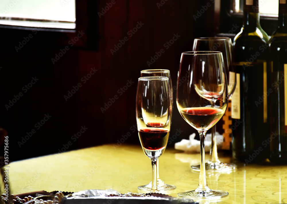 Naklejka premium Red wine in clear wine glass ready to eat or serve for customer. Luxury red wine for rich people place on wooden table decoration in classic and luxury style.